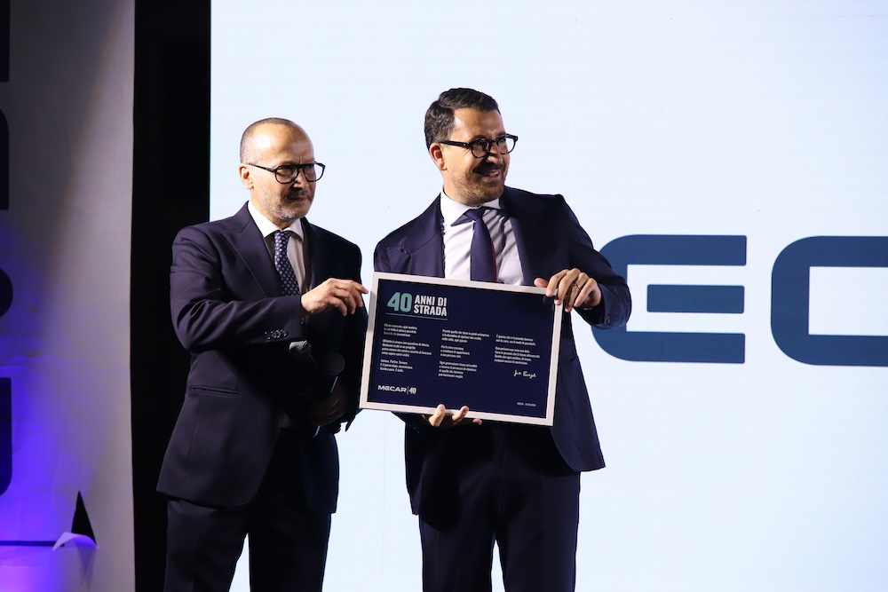 Due persone reggono insieme la targa dei 40 anni